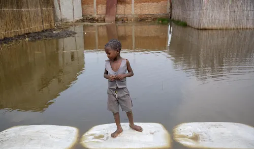 Un enfant se tient debout dans les eaux en crue à Gatumba, au Burundi.