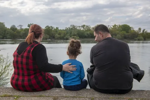 a family in Belgrade, Serbia, within early childhood development programme Caring for the caregivers. Mother and father are playing and painting with their three-year-old son in front of a lake. 