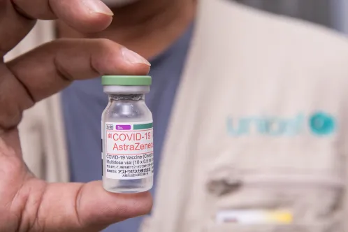 UNICEF representative holding an AstraZeneca Vaccine dose.