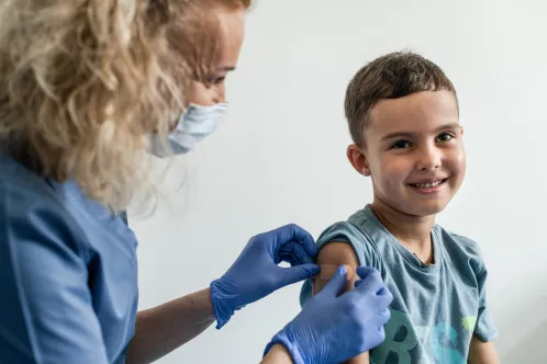 Un garçon âgé de six ans reçoit ses vaccins d’une infirmière du centre médical UNIMED.