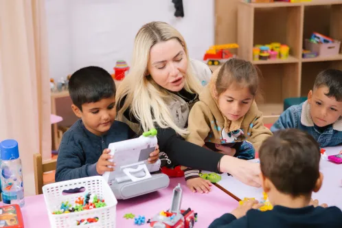 Une employée de l’UNICEF joue avec des enfants dans un espace adapté pour les enfants de l’UNICEF en Türkiye.