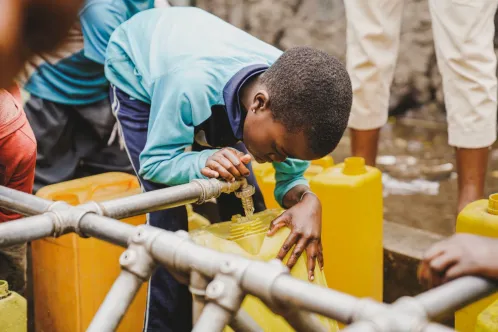 A child fills bucket with clean water in DR Congo