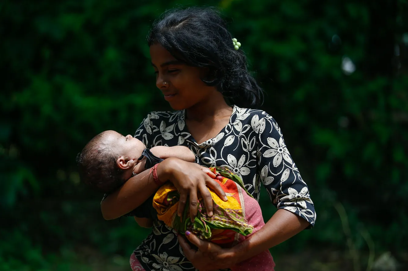 Manisha Raya holds her 28-day-old baby sister.