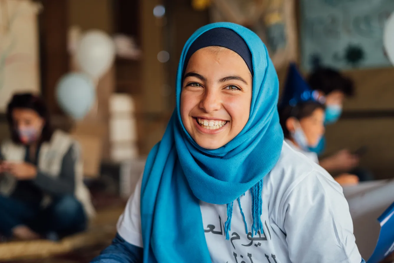 A young girl is wearing blue to celebrate child rights in an informal tented settlement on the outskirts of Amman Jordan.