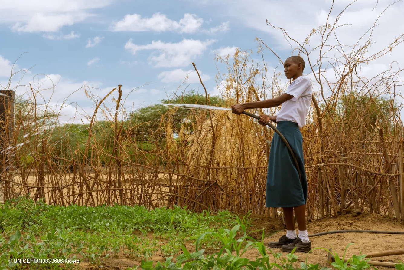 Sharlyne watering pumpkins in the school vegetable garden.