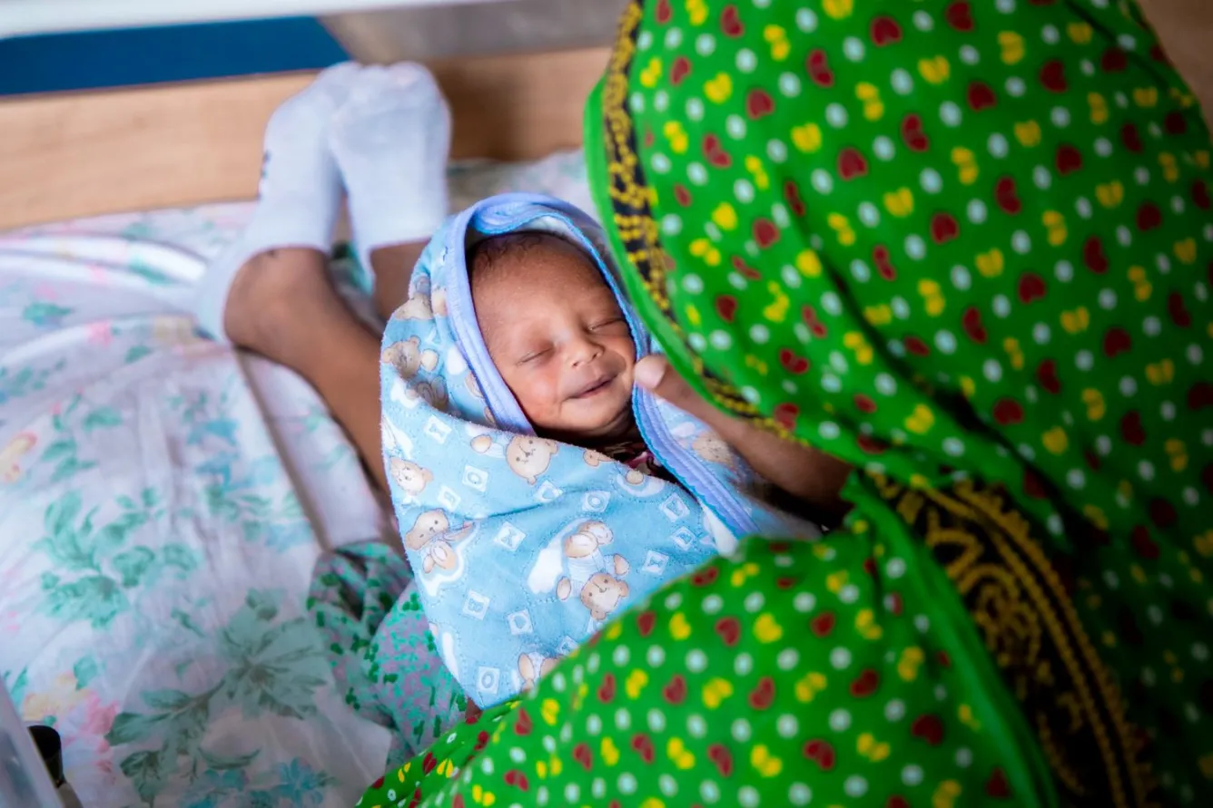 Dans un hôpital en Éthiopie, une mère tient dans ses bras son bébé enveloppé dans une couverture.