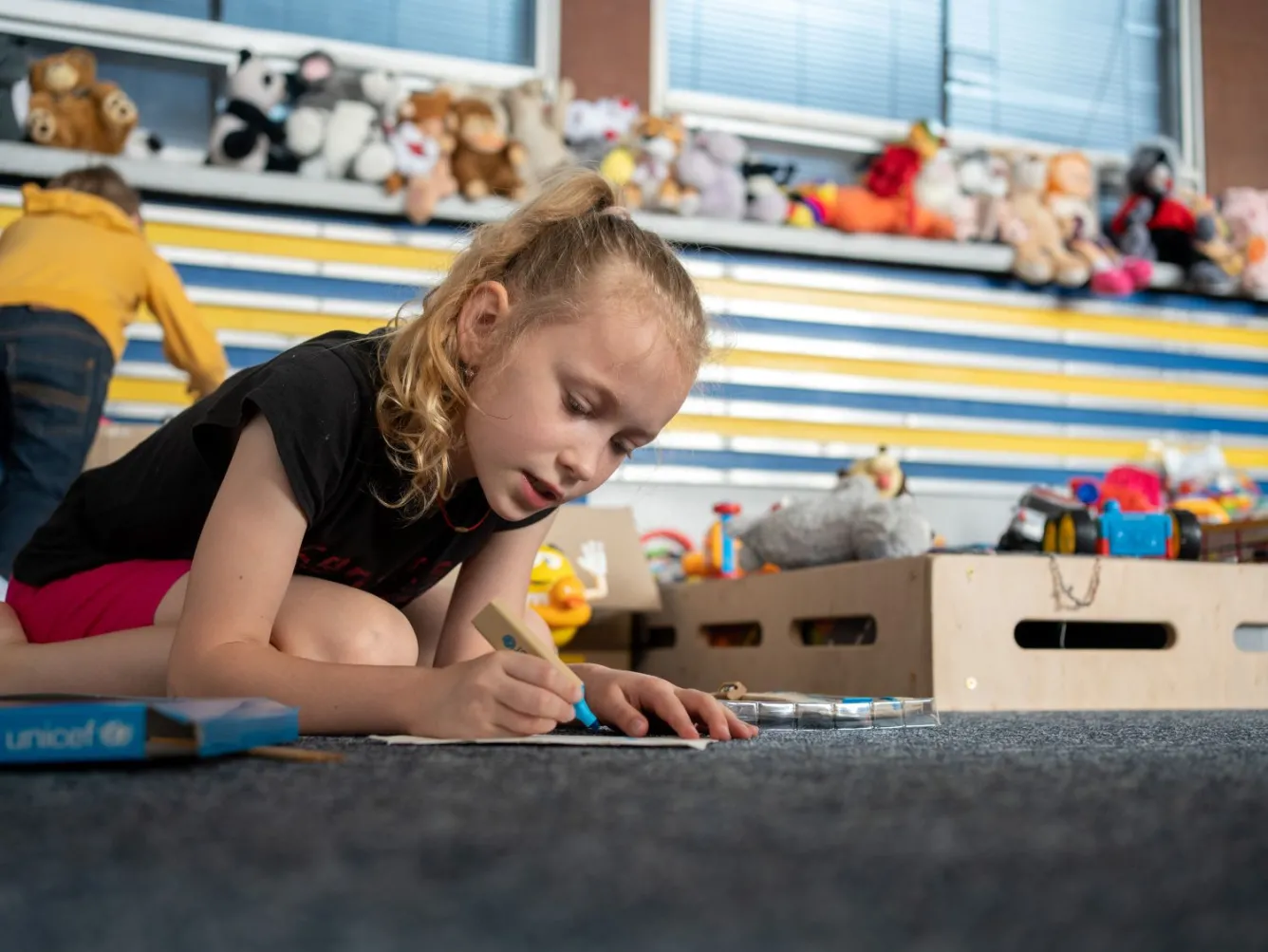 Nine-year-old Polina draws a picture at a UNICEF-supported safe space in Mykolaiv, Ukraine.