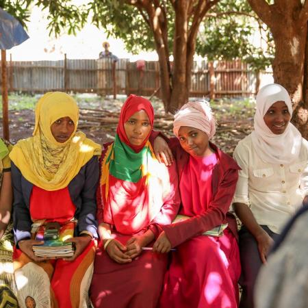 Girls pose together outside their school in Ethiopia.