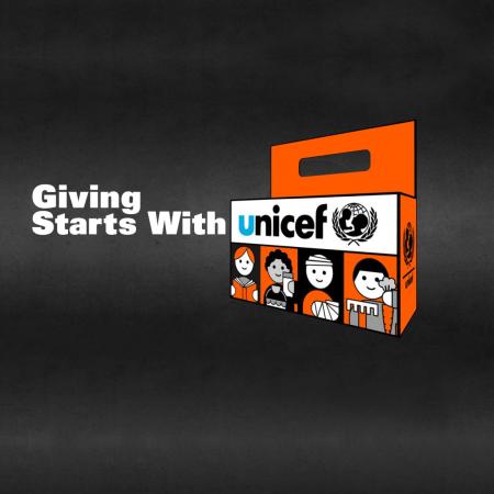 Illustration of the UNICEF Orange Halloween box with text that says “Giving Starts With UNICEF”. The “U” in UNICEF is in cyan while the rest of the word is in black.