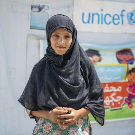 Young girl stands outside a UNICEF Child Friendly Space in Sindh, Pakistan.