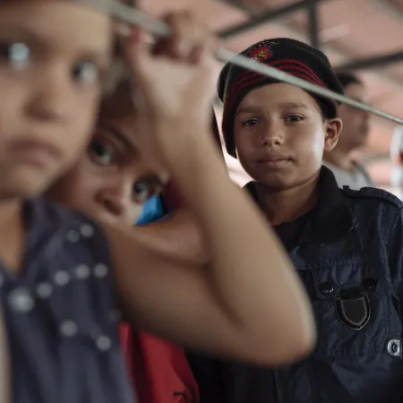 Three boys in a migrant camp tent