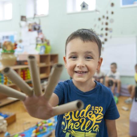 Un jeune garçon sourit et joue dans son école maternelle à Belgrade, en Serbie.