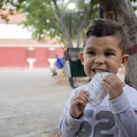 A child eats from a packet of ready-to-use therapeutic food in Venezuela.