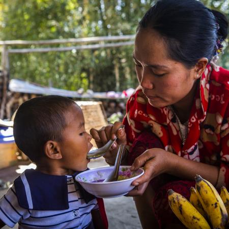 Daw Buu Shane feeding her daughter a nutritous meal cooked with ingredients grown in her backyard. 