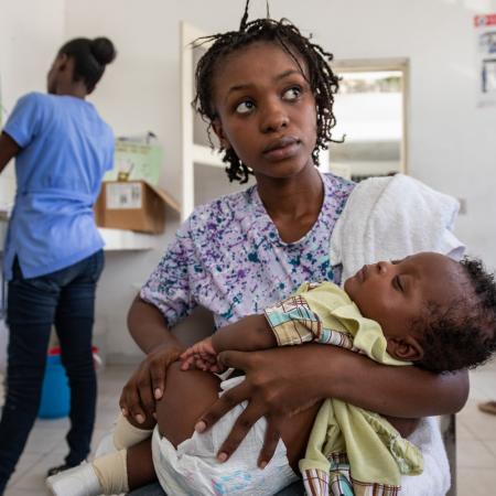 A woman is holding a child in her arms.