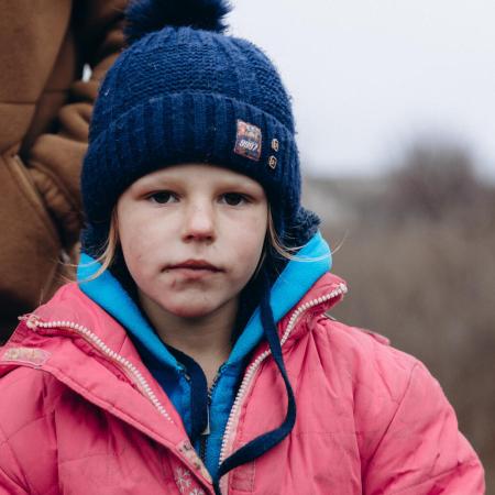 Une petite fille attend de recevoir des fournitures d’urgence à Lyman en Ukraine.