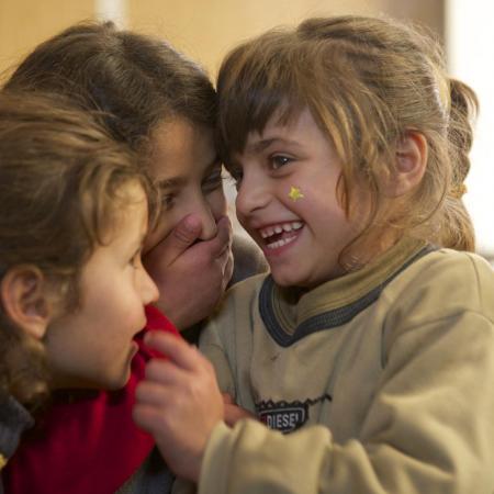 Safa (right) laughs with her twin sister and older sister.