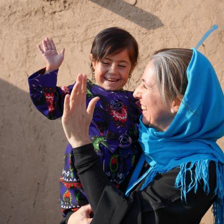 Sam Mort, Chief of Communication for UNICEF Afghanistan, holds Parwana who is a young child in her arms.