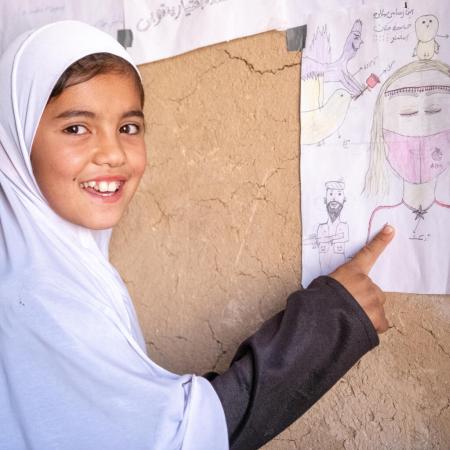 Nine-year-old Khadija shows one of her drawings in her community-based education class supported in Bagh-e-Jalal village, Daikundi province, central Afghanistan.