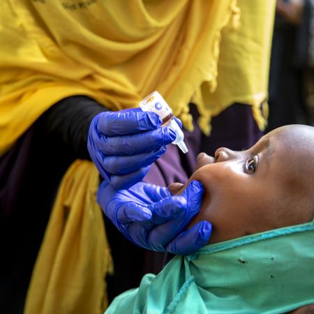 A child in Sudan is receiving a polio vaccination