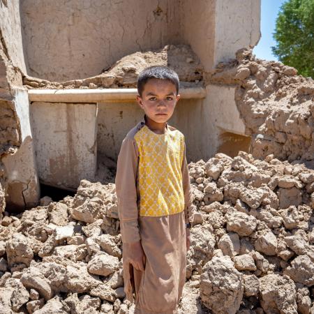On the 28th May 2024, 9 year old Farzan is photographed in the ruins of his house in Chaghcharan district, Ghor province in western Afghanistan.