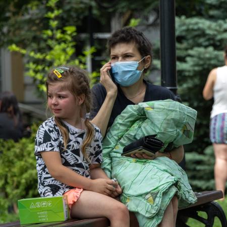 On 8 July 2024 in Kyiv, a child sits on a bench and cries as rescuers, hospital staff and volunteers clear rubble and search for people trapped under debris after an attack that hit Okhmatdyt hospital, Ukraine's largest children's medical centre.