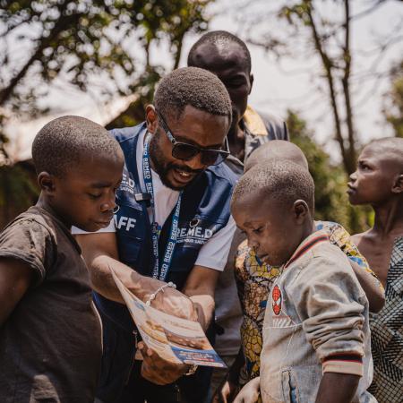 A health worker is seen educating children about mpox symptoms and prevention measures.