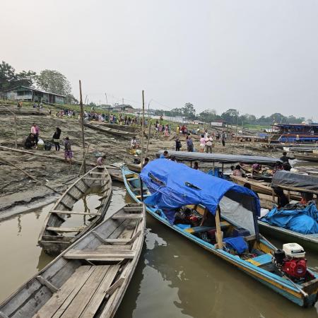 Small fishing ships seem to be stranded on a water front as the flood waters dissipate