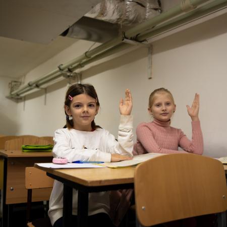 Fourth-grade students attend a lesson in a basement classroom.