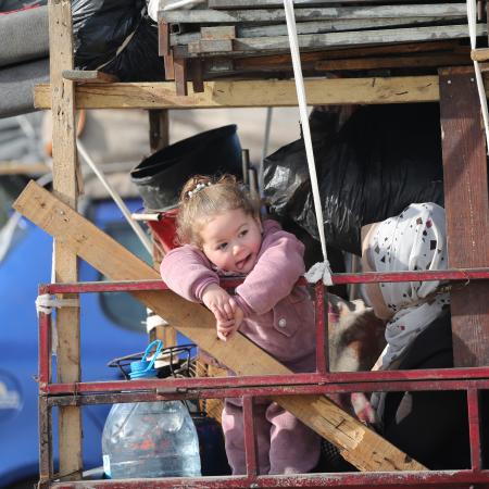 A child looks on as she returns back to her home in Gaza